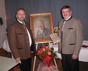 Leo Whr und Sepp Hatzl mit der Originalausgabe der Chronik vor einem Bildnis Brunhubers